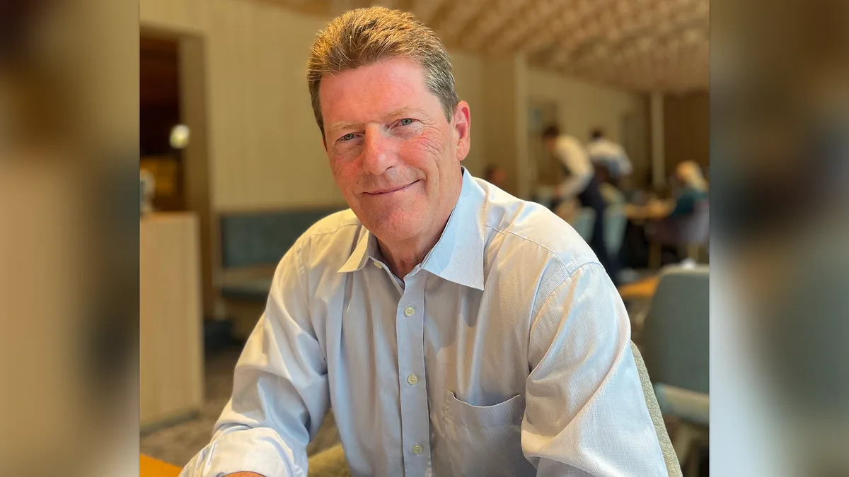 Porträt eines älteren Mannes mit gräulichem Hemd.